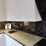 Biała kuchnia na wymiar w połysku z czarnym blatem i nowoczesnym wykończeniem 4